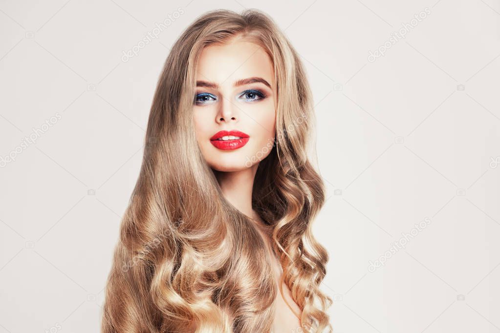 Pretty blonde model woman with long healthy curly hair on white