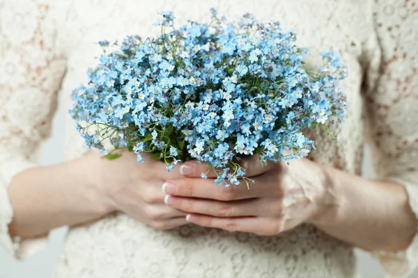 Flores azules en manos femeninas — Foto de Stock