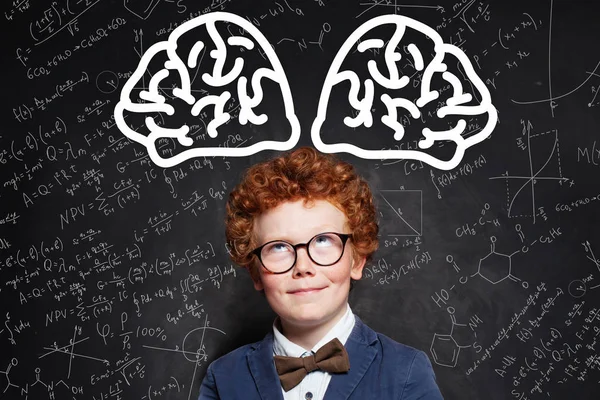 Kisfiú tanuló szemüvegben, agyvelővel a táblán — Stock Fotó