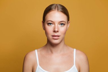 Sarı arka planda genç bir model kadın.