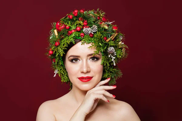 Mooie vrouw in kerst decor op rode achtergrond — Stockfoto