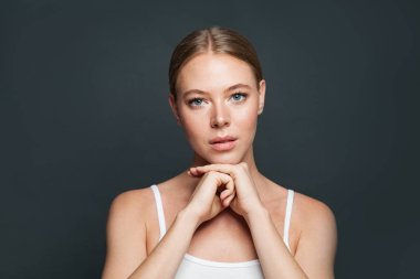 Gri arka planda hoş bir genç kadın.