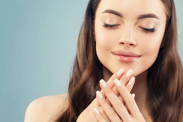 Ładna kobieta z manicure paznokcie na niebieskim tle, zbliżenie twarzy — Zdjęcie stockowe