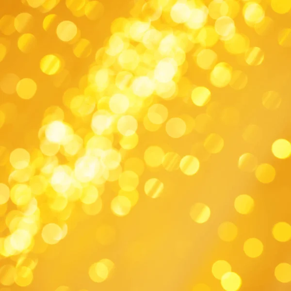 Όμορφο χρυσό φως των Χριστουγέννων φόντο με λαμπερό φόντο glitter. Defocused φόντο με χρυσά αστέρια αναβοσβήνει — Φωτογραφία Αρχείου