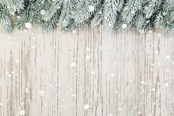 Xmas gran gren på träskiva med vit snö. — Stockfoto