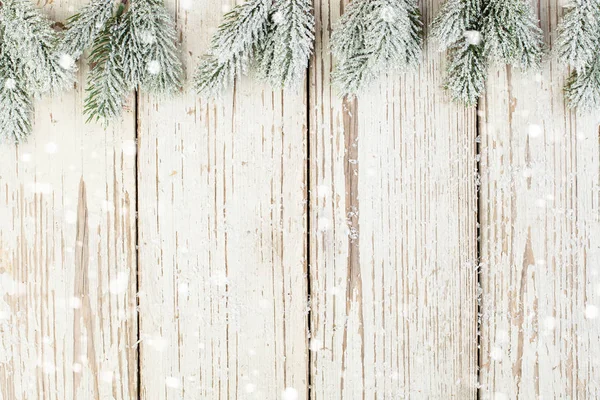 Świąteczna kartka śnieżna z zieloną jodłą na białej drewnianej desce — Zdjęcie stockowe