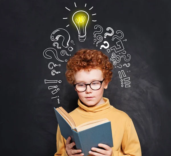 Kind liest auf Tafel Hintergrund mit Glühbirne — Stockfoto