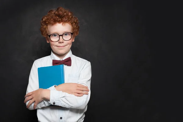 Boy 9 years old holding book on black banner background — Stock fotografie