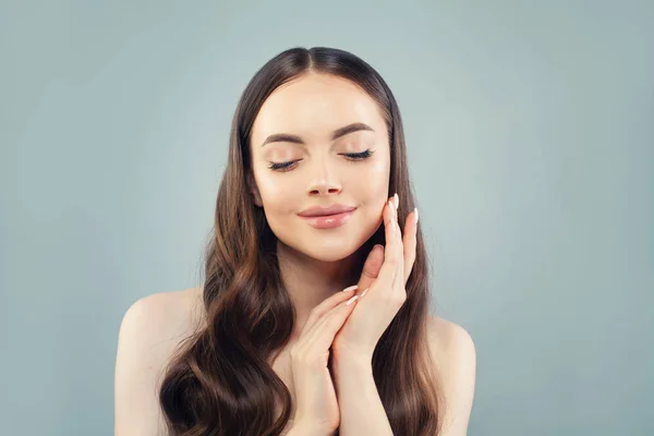 Beautiful woman touching her skin her hand on blue background