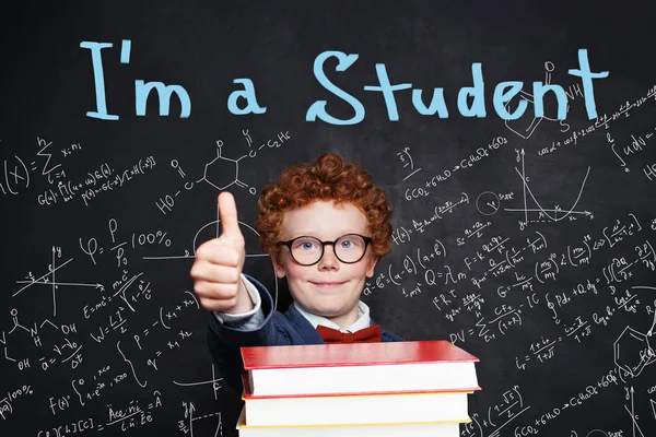 Kid school boy in student uniform holding books and showing thumb up — 스톡 사진