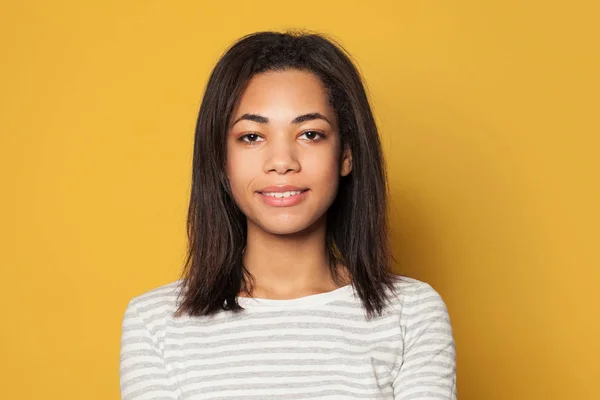 Pretty smiling girl on yellow background portrait — 스톡 사진