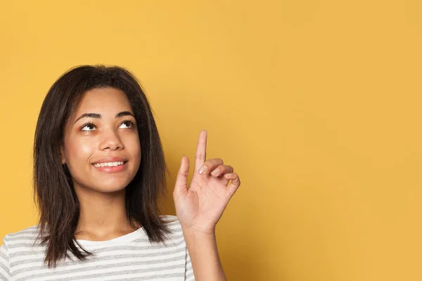 Giovane donna adolescente punta il dito su sfondo giallo — Foto Stock