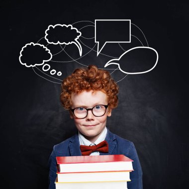 Kara tahtada kitap tutan kızıl kıvırcık saçlı yakışıklı çocuk.