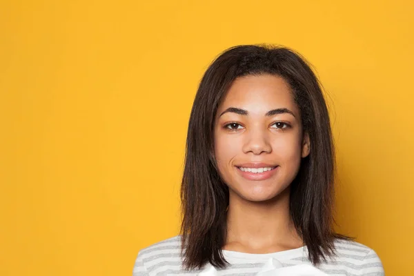 Retrato de mulher afro-americana sorridente em fundo amarelo — Fotografia de Stock