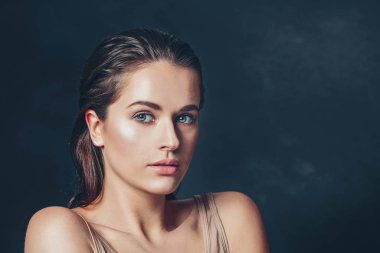 Koyu arkaplanda ıslak tenli güzel bir kadın.