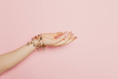 Pembe arka planda genç bir kadın. Kadın el ele tutuşması hediyesi.