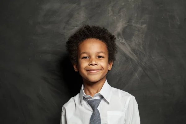 Счастливого чёрного мальчика. Симпатичный ребенок на фоне школьной доски — стоковое фото