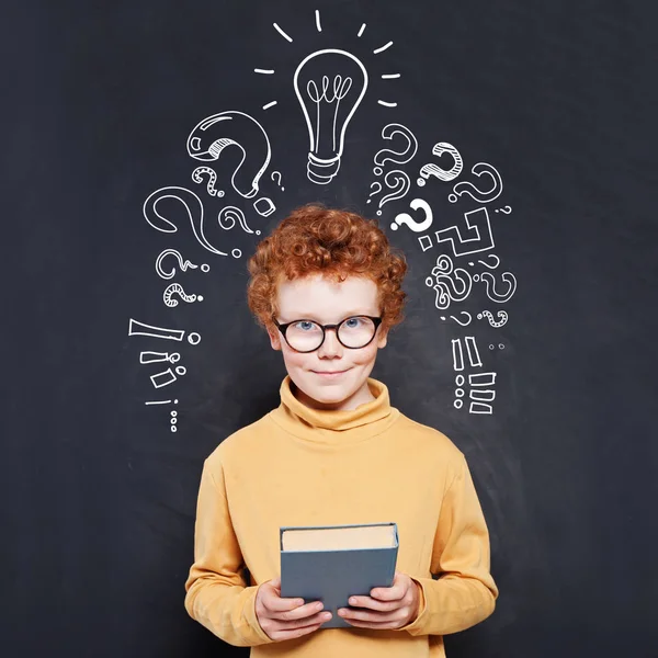 Child boy and book, idea lightbulb and question marks — ストック写真