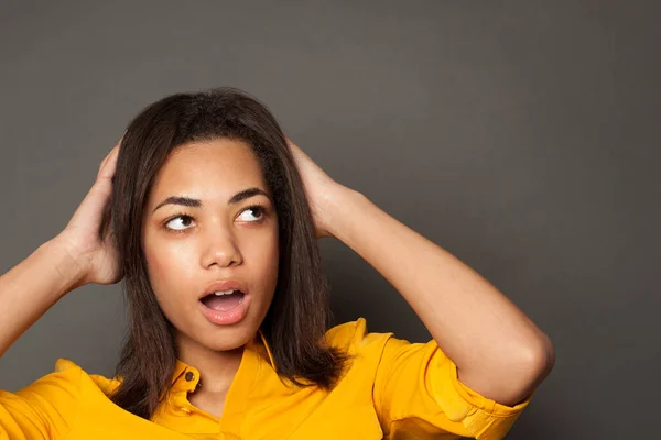 Shocked black woman on gray background