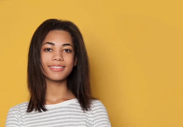 Estudante de mulher afro-americana bonita sorrindo no fundo amarelo — Fotografia de Stock