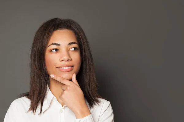 Smart black girl student thinking and smiling on gray background — 스톡 사진