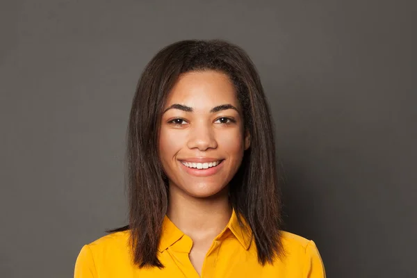 Inteligente menina negra estudante sorrindo no fundo cinza — Fotografia de Stock