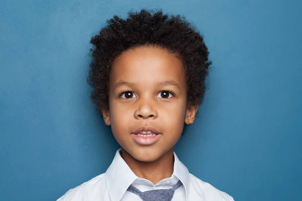 Kis fekete fiú diák kék háttér közelkép portré — Stock Fotó