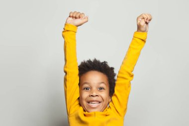 Mutlu Afrikalı Amerikalı çocuk beyaz arka planda eğleniyor.