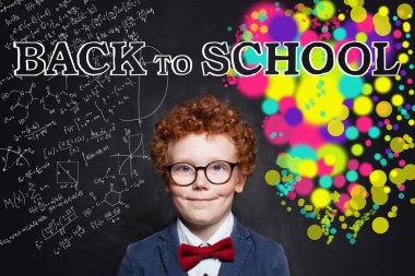 Okul konseptine geri dönelim. Gözlüklü ve öğrencili mutlu akıllı çocuk.