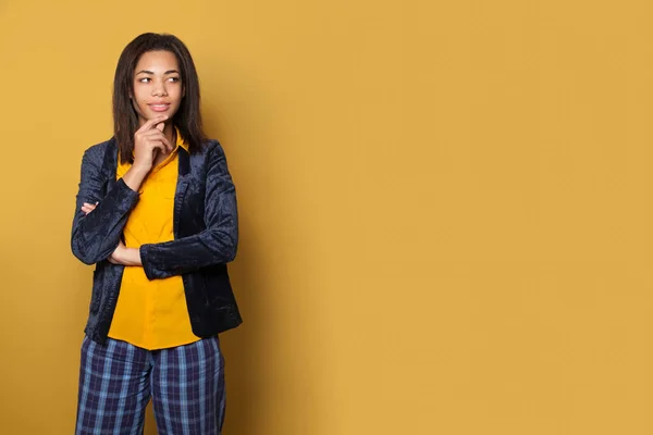Intelligente schwarze Studentin denkt auf gelbem Hintergrund — Stockfoto