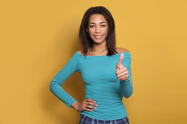 Fröhliche schwarze Frau zeigt Daumen nach oben auf gelbem Hintergrund — Stockfoto