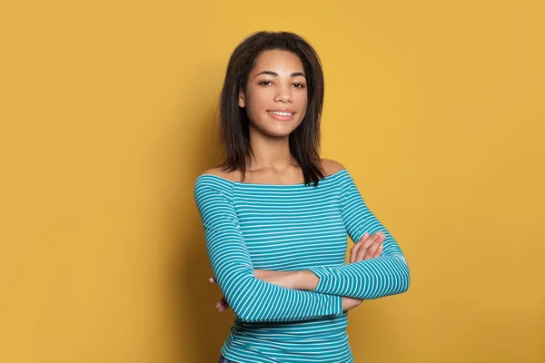 Happy black model woman with crossed arms on yellow background — 스톡 사진