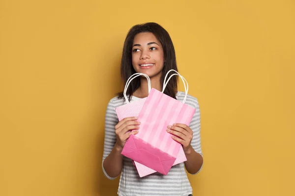 Mujer afroamericana bastante joven sosteniendo bolsas de compras rosadas —  Fotos de Stock