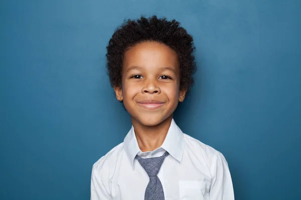 Portrét černého žáka na modrém pozadí. Šťastné dítě — Stock fotografie