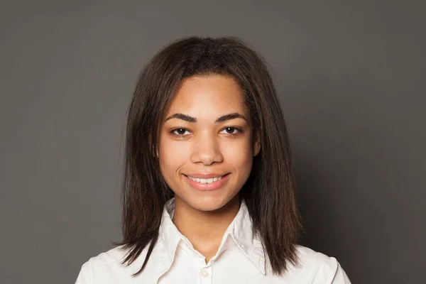 Young confident black woman student smiling on gray background, — Stock Photo, Image