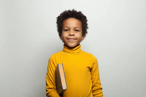 Симпатичный афроамериканец держит книгу о белом — стоковое фото