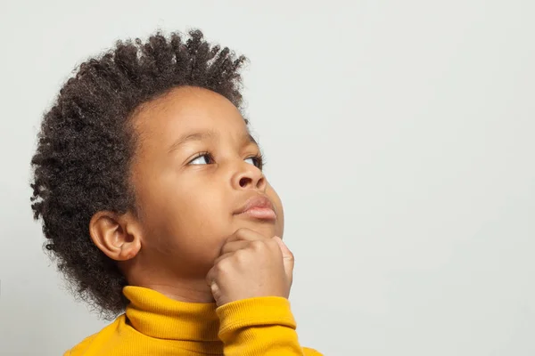 Pouco inteligente curioso menino preto criança pensando no fundo branco — Fotografia de Stock