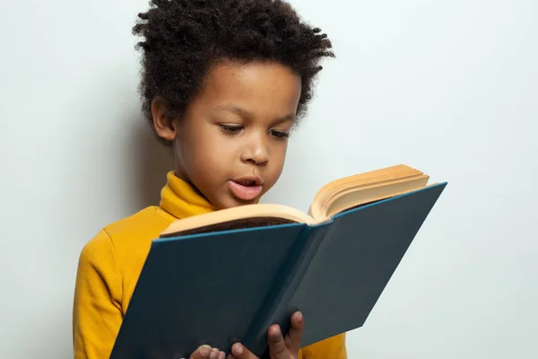Klein Afrikaans Amerikaans kindje leest een boek over wit — Stockfoto