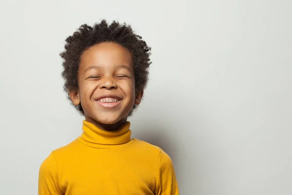 Милий школяр чорний хлопчик сміється на білому тлі — стокове фото