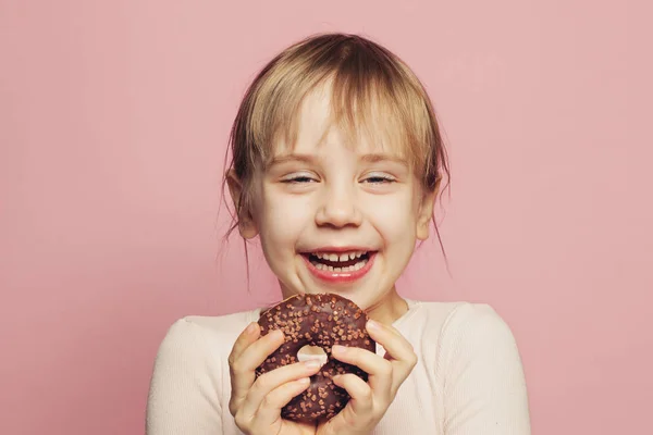 Petite fille mignonne riant et s'amusant avec beignet au chocolat — Photo