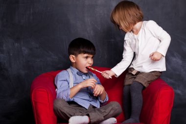 Syster küçük kardeşine şeker kırmızı lolipop veriyor.. 