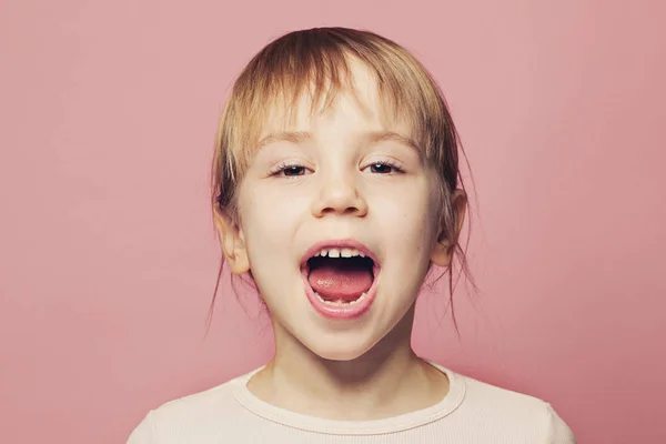 Happy child girl screaming on pink background — ストック写真