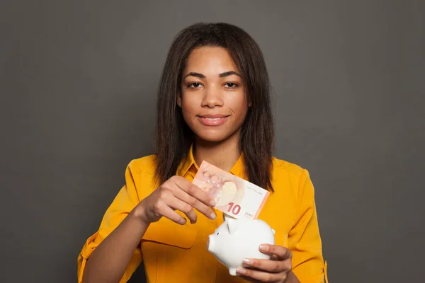 Young Smart Black Woman Putting Piggy Bank Euro Banknote — Stock Photo, Image
