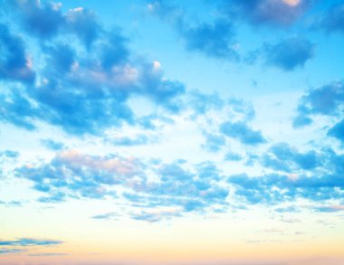 Mavi gökyüzü arka planda. Bulutları ve gökyüzünde turuncu güneşi olan güzel bir manzara.