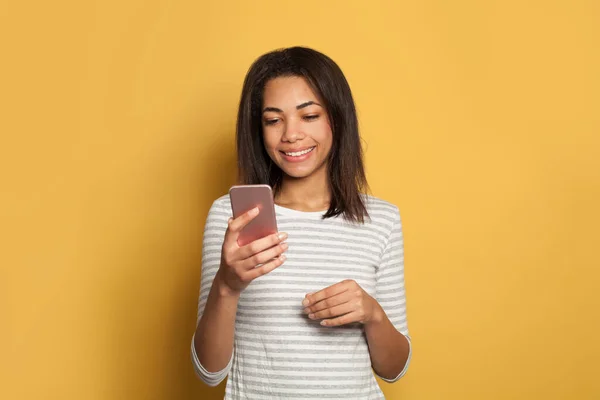 Glückliche Schwarze Frau Mit Smartphone Und Lächeln Auf Buntem Gelben — Stockfoto