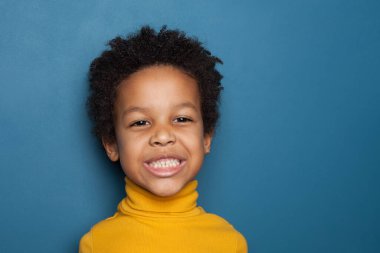 Mavi arka planda yaramaz siyah çocuk