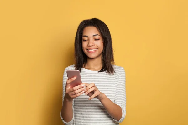 Schwarze Studentin Mit Smartphone Auf Leuchtend Gelbem Hintergrund — Stockfoto