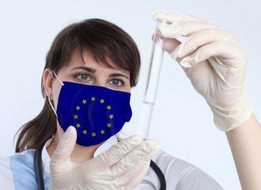 Avrupa Birliği bayrağı taşıyan bilim kadını ve maske. Eu 'daki bir salgının önlenmesi için laboratuvarda virüs araştırması