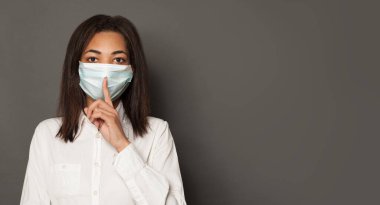 Siyah arka planda yüz maskesi takan genç siyah bir kadın. Tıbbi maskeli kadın. Grip salgını ve virüs koruma kavramı