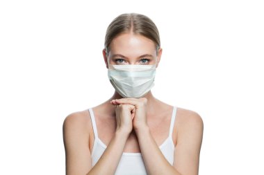 Beyaz arka planda tıbbi maske takan yalnız bir kadın.